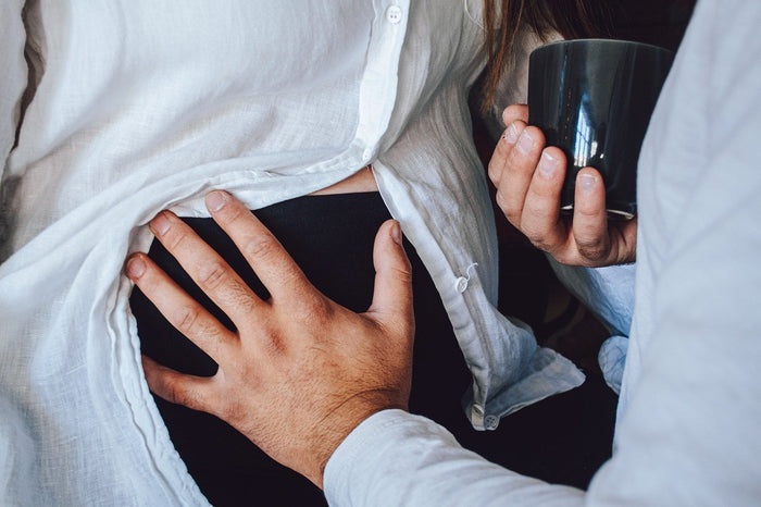 Vater legt Hand auf Bauch seiner schwangeren Frau